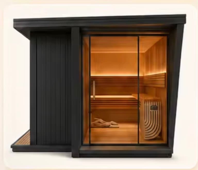 Outdoor Recovery Labz sauna with a black exterior and a full-height glass front, lit warmly from inside